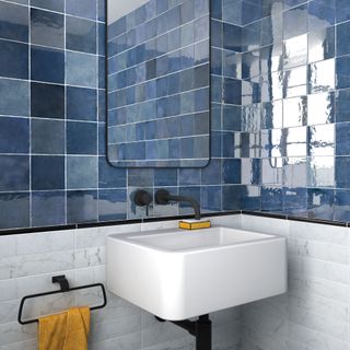 Bathroom with half wall tiled in gloss blue tiles and half wall tiled with white marble tiles