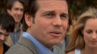 Bill Paxton stands in conversation while Alan Ruck and Helen Hunt watch on in Twister.