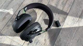 Razer Blackshark V3 wireless headset against a grey background with dongle