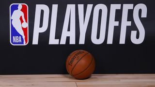 A basketball sits next to an NBA Playoffs logo 