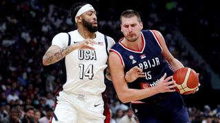 Nikola Jokic (R) all in blue, takes on Anthony Davis (L), in all white, ahead of Serbia vs USA in the men's basketball at the 2024 Olympic Games.