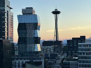 The view of the Space Needle at dusk from the ALTITUDE Rooftop Lounge at the Astra Hotel Seattle