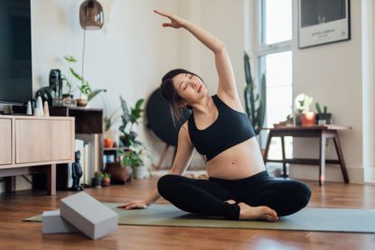 Amazon Black Friday fitness deals: A woman stretching in her living room