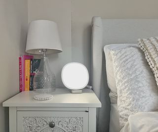 lumie dash on cream bedside table next to neutral coloured bed