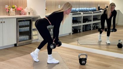 A female personal trainer does a single leg dumbbell RDL