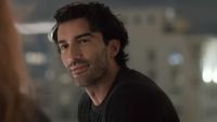 Justin Baldoni as Ryle smiling in a close-up during the rooftop scene of It Ends With Us.