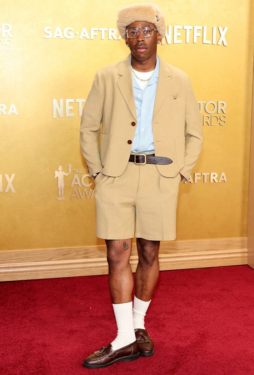 tyler the creator wears a beige blazer and shorts.
