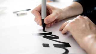 Person writing lettering with a marker