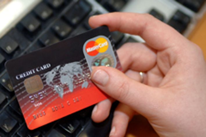 Woman holding a credit card over a keyboard