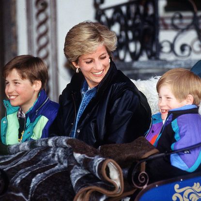 LECH, AUSTRIA - MARCH 30: Princess Diana With Prince William And Prince Henry (harry) In Lech, Austria. They Are Sitting In A Carriage With A Blanket Covering Them. Sitting Behind Is Their Nanny Olga Powell. (Photo by Tim Graham Photo Library via Getty Images)