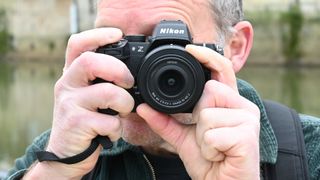 Man looking through Nikon Z50 II viewfinder