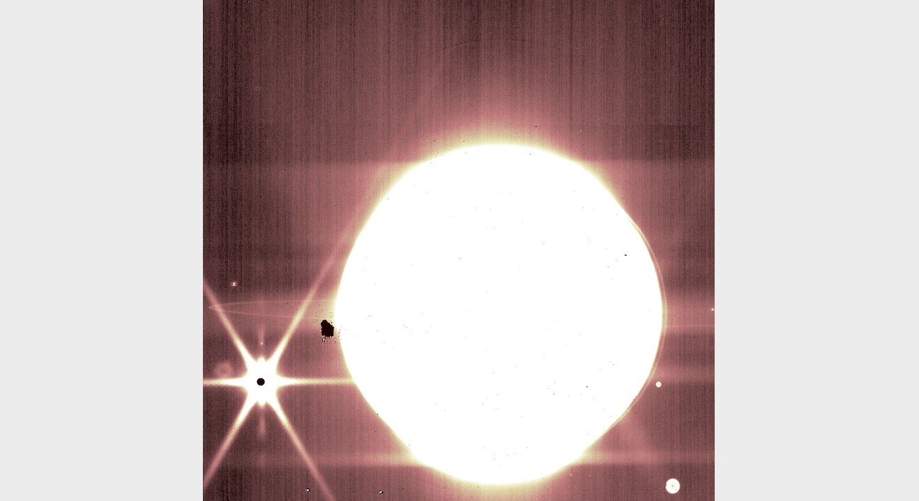 Jupiters un daži tā pavadoņi ir redzami caur Džeimsa Veba kosmiskā teleskopa NIRCam 3,23 mikronu filtru.