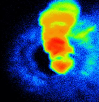 A heatmap style image showing an iron sample heated up, with red in the middle and blue around the outside.