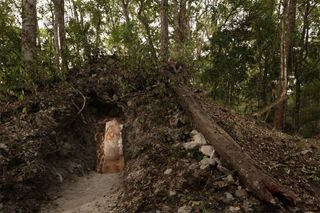 The painted figure of a man, possibly a scribe who once lived in the house built by the ancient Maya, is illuminated through a doorway to the dwelling, in northeastern Guatemala. The structure represents the first Maya house found to contain artwork on it