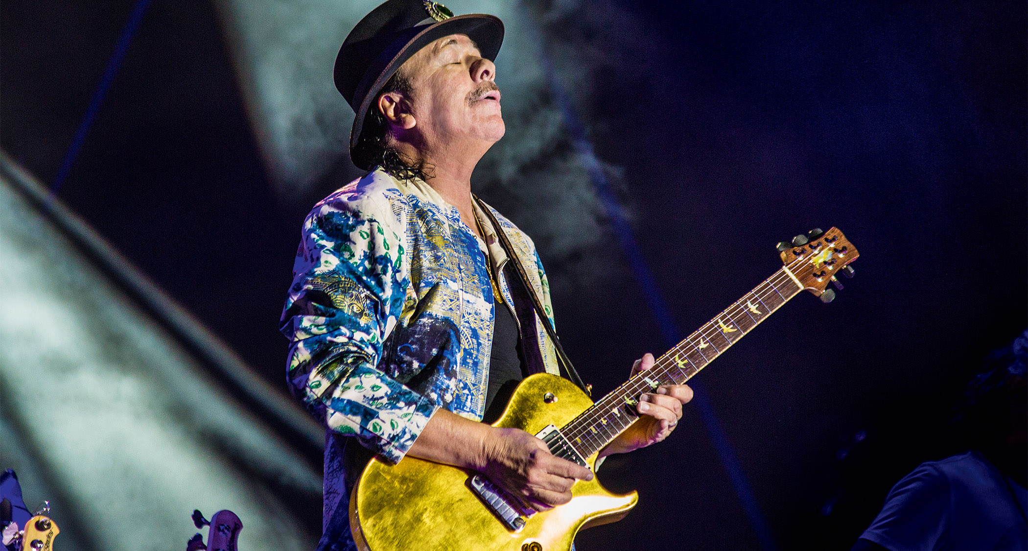 Carlos Santana plays a gold PRS singlecut live, hitting a not and holding it.