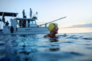 Annett Bening as Diana Nyad in the sea with a boat behind her