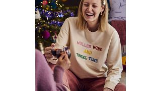 Best Christmas jumpers illustrated with a sweatshirt embroidered with mulled wine and tinsel time