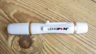 LensPen lens cleaner on a wooden floor