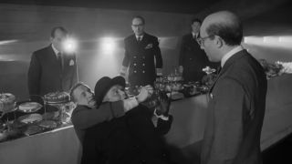 George C Scott holding a man while Peter Sellers and others watch in Dr. Strangelove.