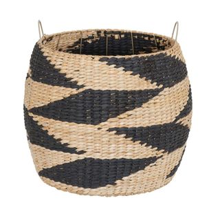 A woven storage basket with a black zig zag pattern