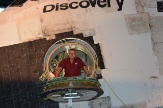 Dennis Jenkins, author of "Space Shuttle: Developing an Icon, 1972-2013," looks out through the crew access hatch on the space shuttle Discovery.