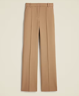 a pair of pleated jcrew pants in front of a plain backdrop