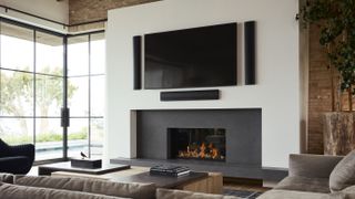 Definitive Technology Mythos on wall speakers flanking TV above fireplace