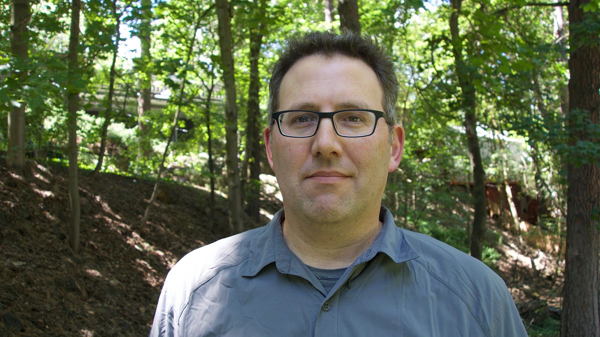 A headshot of Michael Glavin in a forest