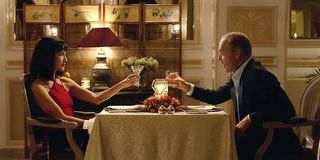 Maggie Q and Michael Keaton drinking together in The Protege