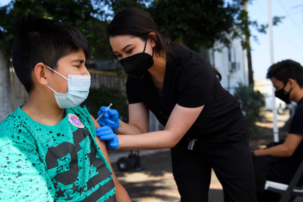 Twelve-year-old Jair Flores receives a first dose of the Pfizer Covid-19 vaccine at a mobile vaccination clinic on May 14, 2021 in Los Angeles, California. 