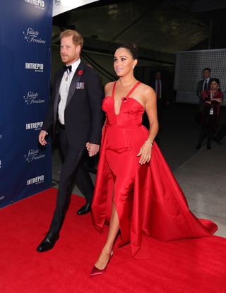 Meghan Markle wearing a red Carolina Herrera dress to an event with Prince Harry