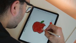 A man drawing with an Apple Pencil on an iPad.