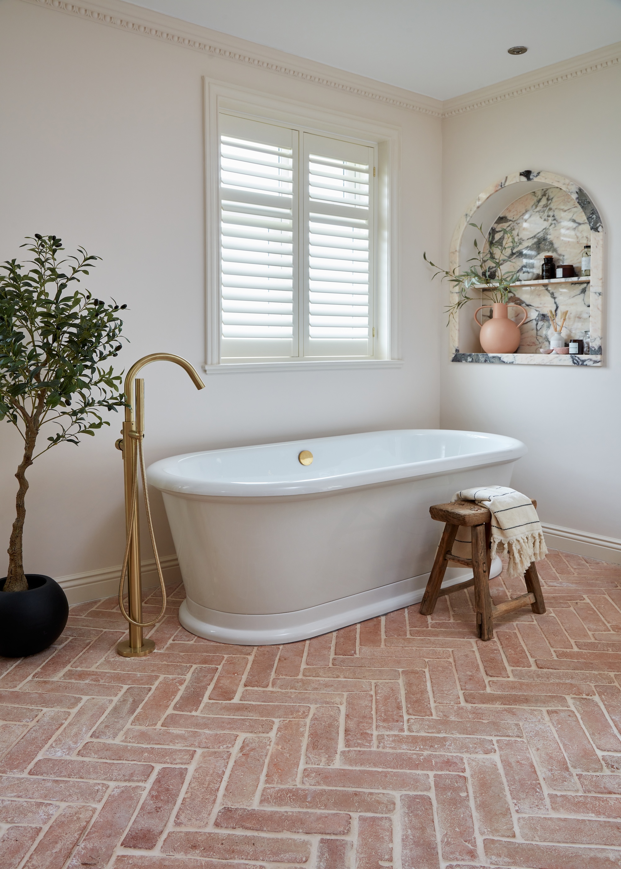 terracotta herringbone tile floor in a bathroom with a tub