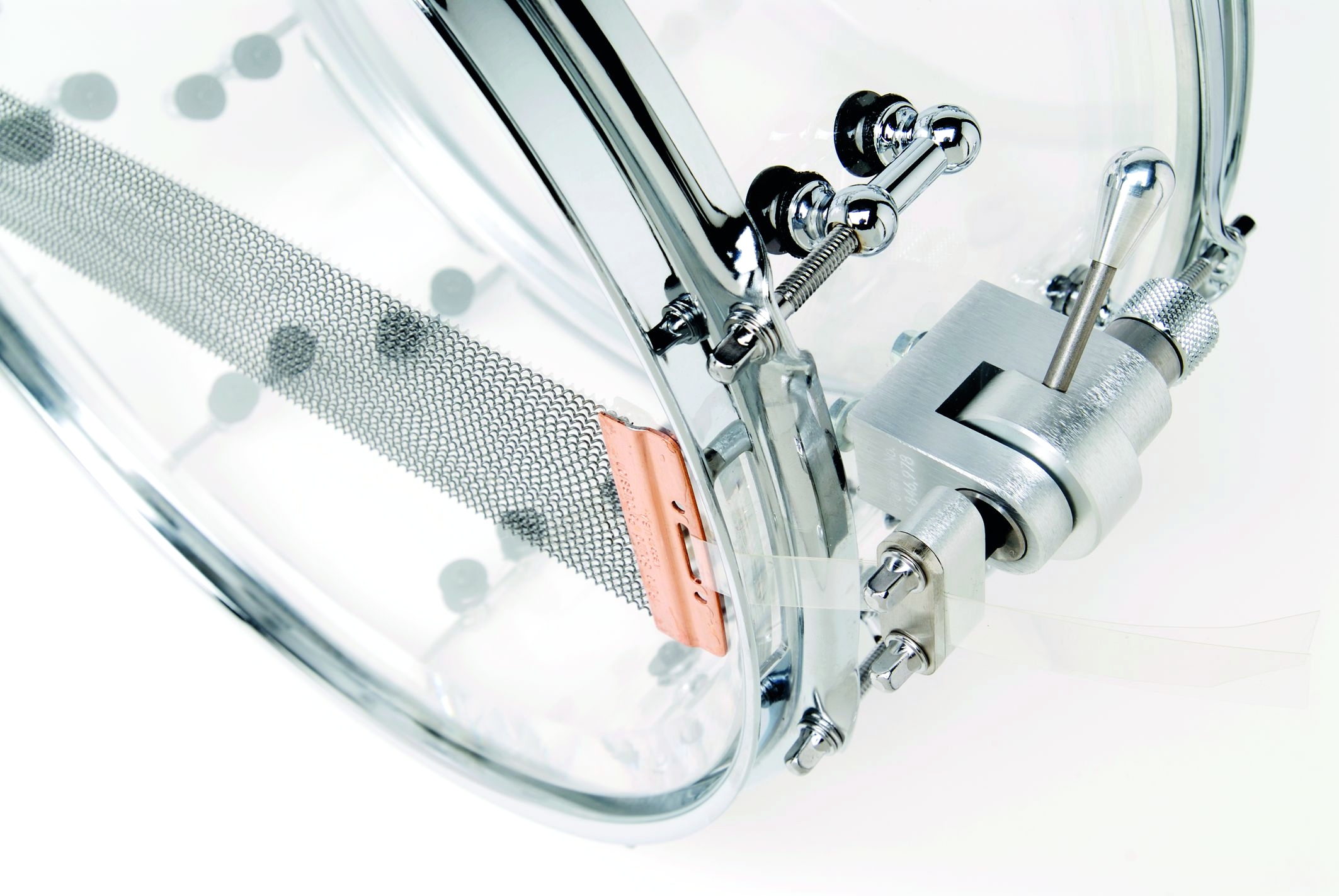 The clear shell snare drum has offset mini tube lugs and is fitted with Trick strainer and 24-strand Puresound snares