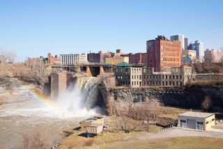 Waterfalls of Rochester, NY, USA. The waterfalls are in the foreground and buildings in the background.