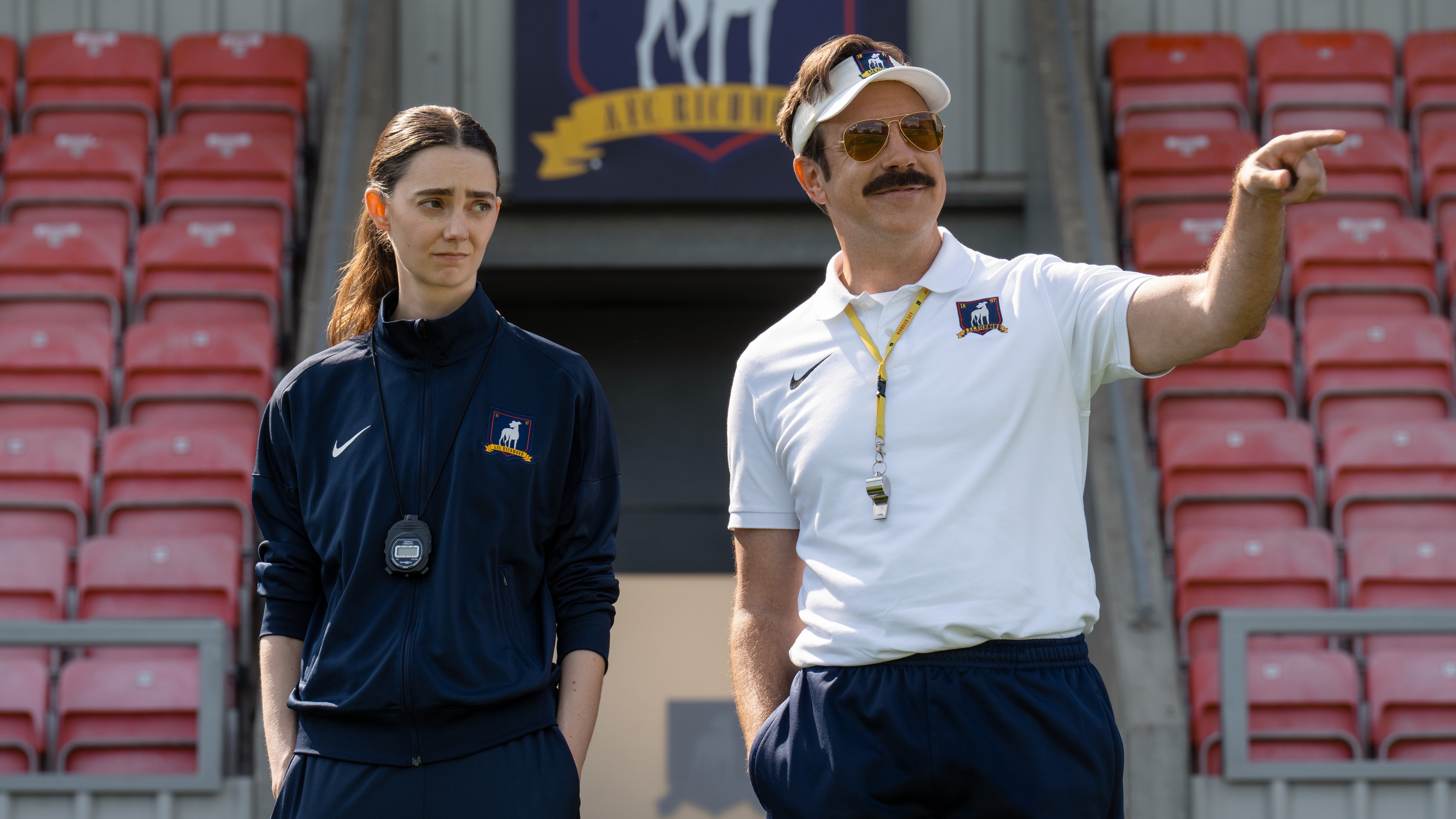 Tanya Reynolds and Ted Lasso (Jason Sudeikis) coaching on the football pitch.