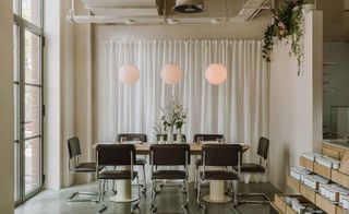 Seating for a table of eight below three spherical glass lights