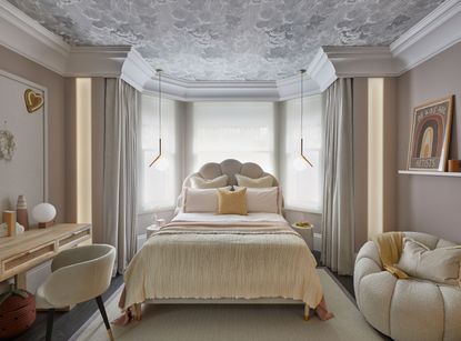 a bedroom with a cloud wallpaper ceiling