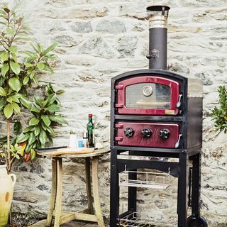 outdoor oven on black trolley and wooden stool