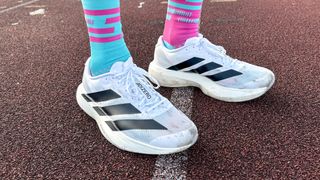 Person wearing the Adidas Adizero Evo SL on a running track