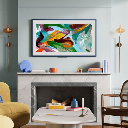 Amazon Ember Artline TV mounted on a blue wall over a marble fireplace