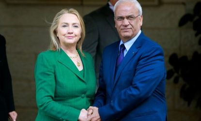 U.S. Secretary of State Hillary Clinton holds hands with senior Palestinian official Saeb Erekat after meeting with Palestinian President Mahmoud Abbas in the West Bank city of Ramallah on No
