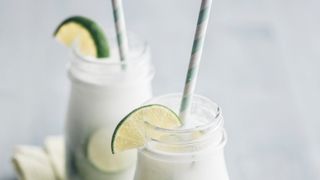 Lime and coconut water slushie with lime wedge and straw