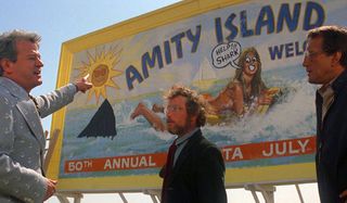 Murray Hamilton, Richard Dreyfuss, and Roy Schieder arguing in front of a billboard in Jaws.