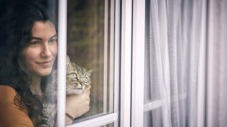 Woman and cat looking out of the window