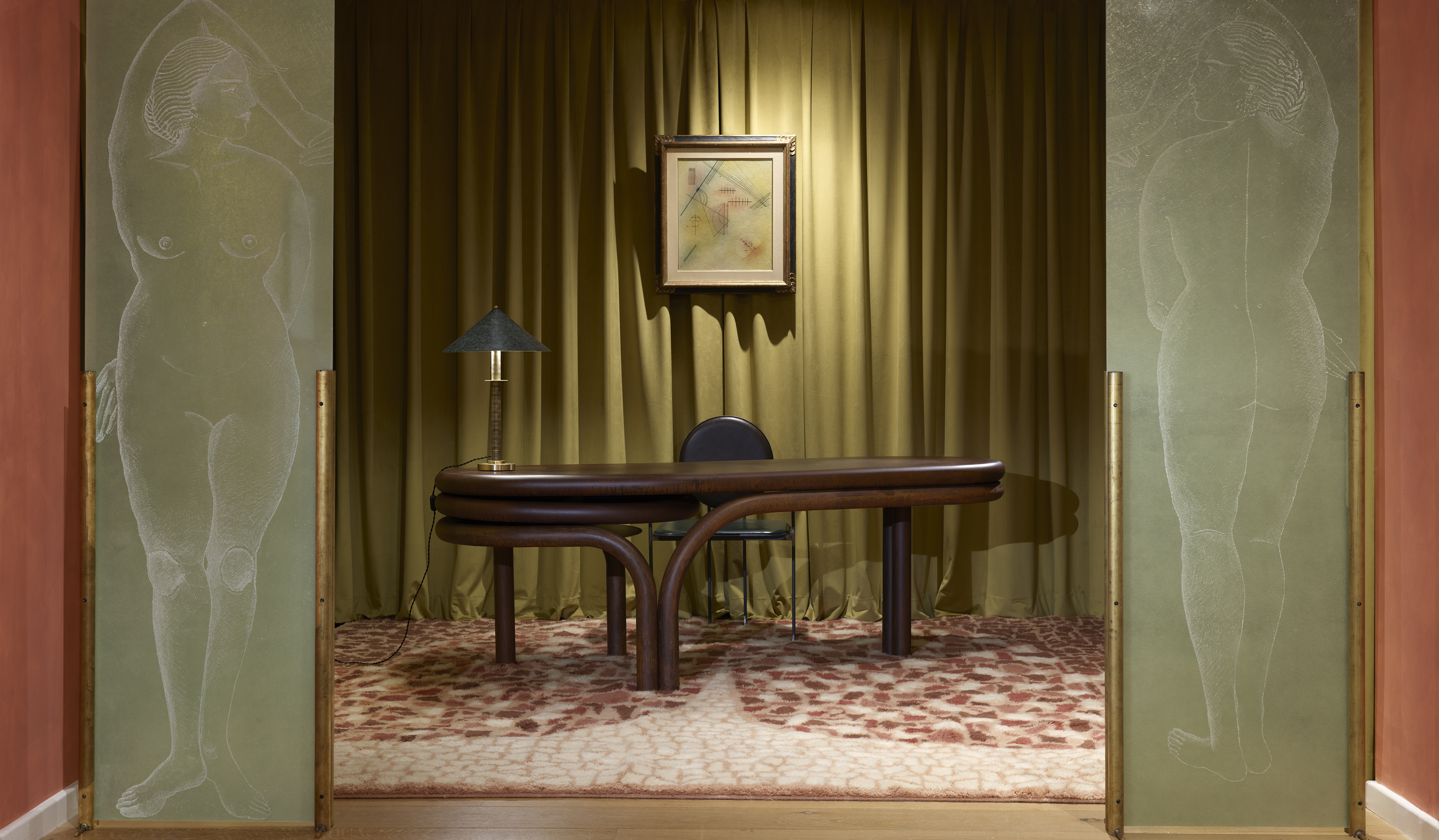 Room at Casa Milana with green curtain in background and desk with dark green chair and lamp