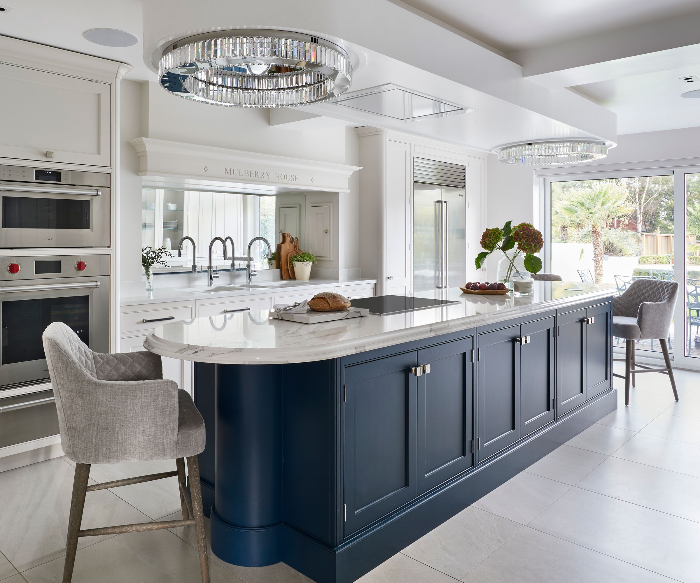 large blue kitchen island with hob and built-in cooker hood