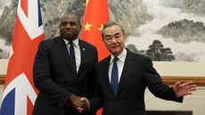 Britain's Foreign Secretary David Lammy (L) and Chinese Foreign Minister Wang Yi shake hands before their meeting at the Diaoyutai State Guesthouse in Beijing