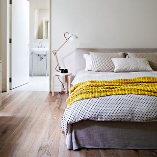 neutral bedroom with lime washed floor with double bed