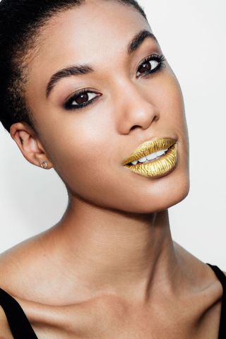 Model wearing gold lipstick